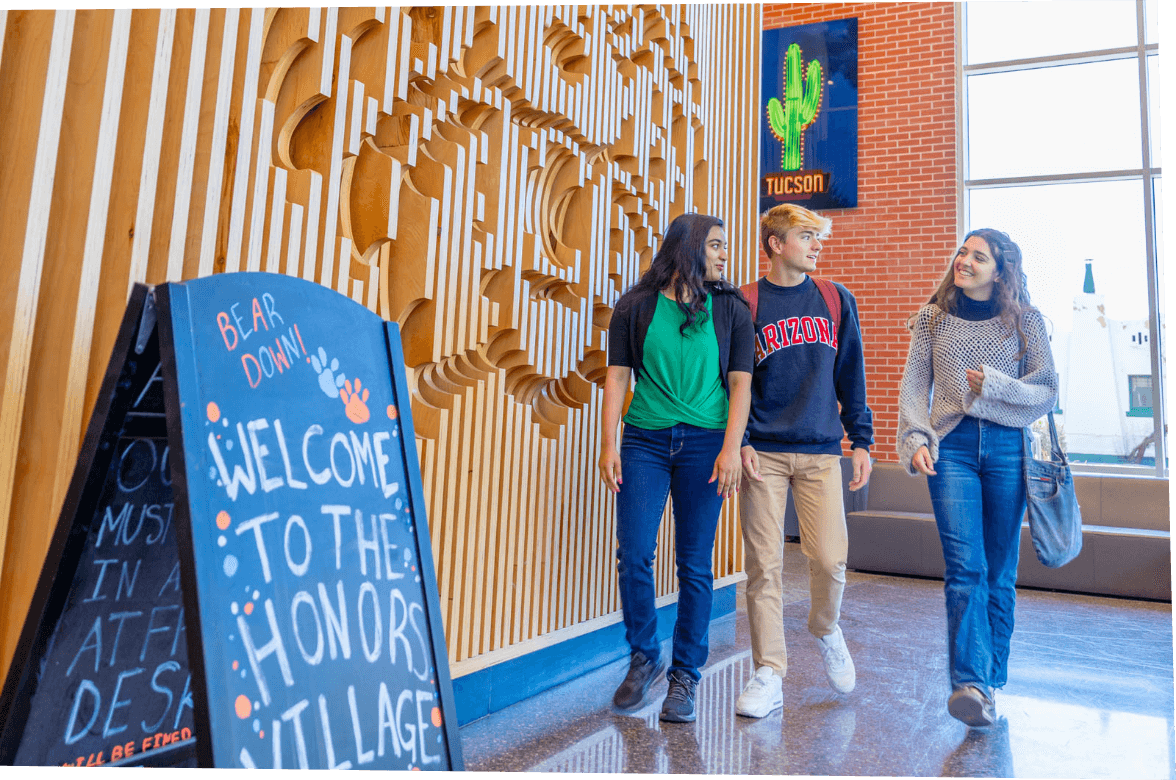 Students talking inside a dorm lobby with welcome sign